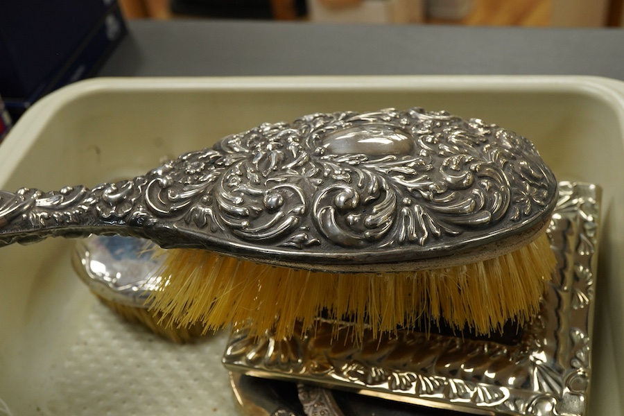A small group of silver and white metal items, including an Edwardian silver and tortoiseshell mounted hand mirror by Samuel Jacob, 26.1cm, a silver mounted hair brush, a small silver mounted brush, a repousse silver pin